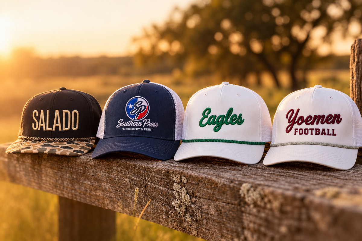 Southern Press custom embroidered hats on a fence post: Salado, Southern Press, Eagles, Yoemen Football